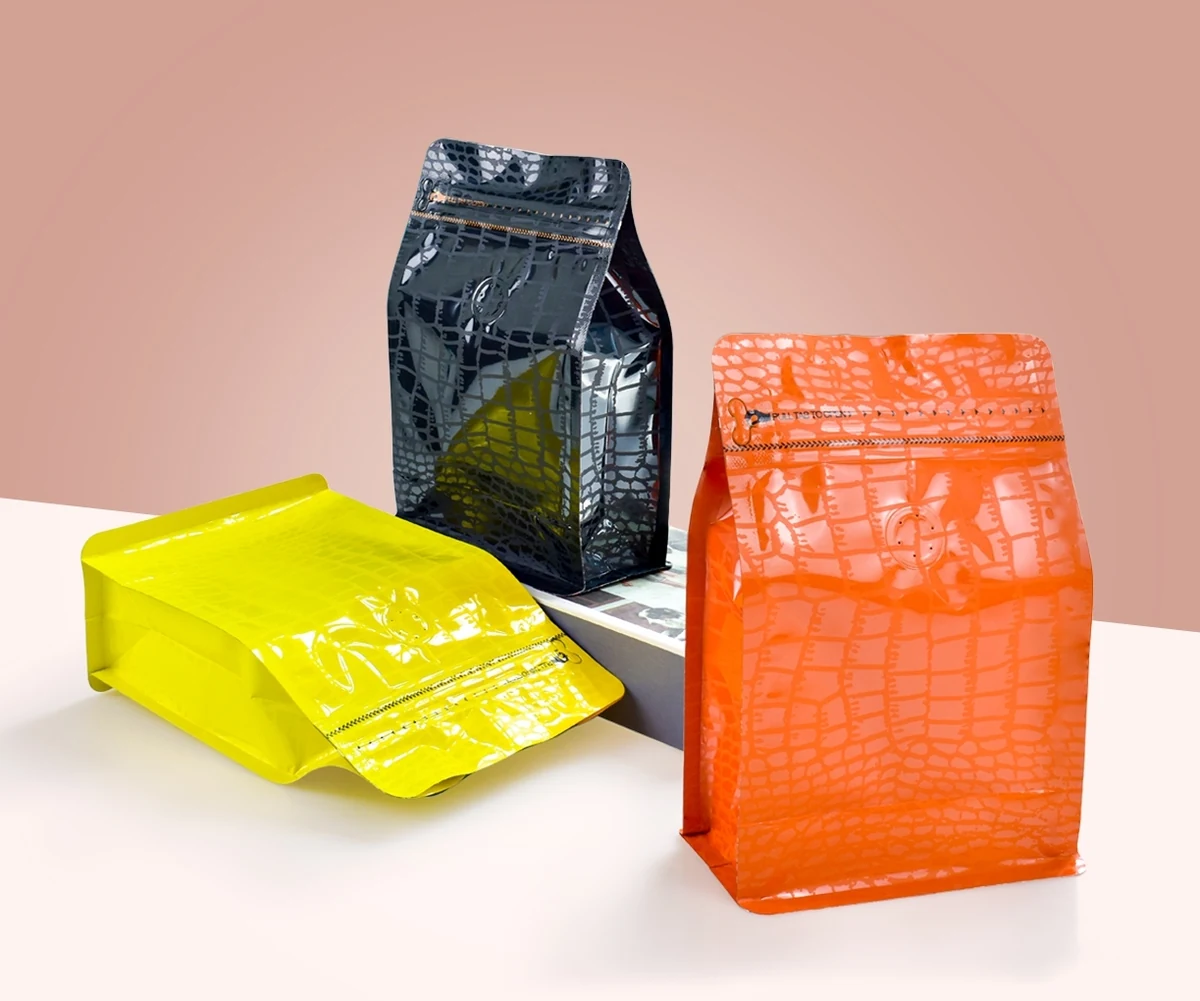 Textured flat-bottom coffee bags in yellow, charcoal and orange